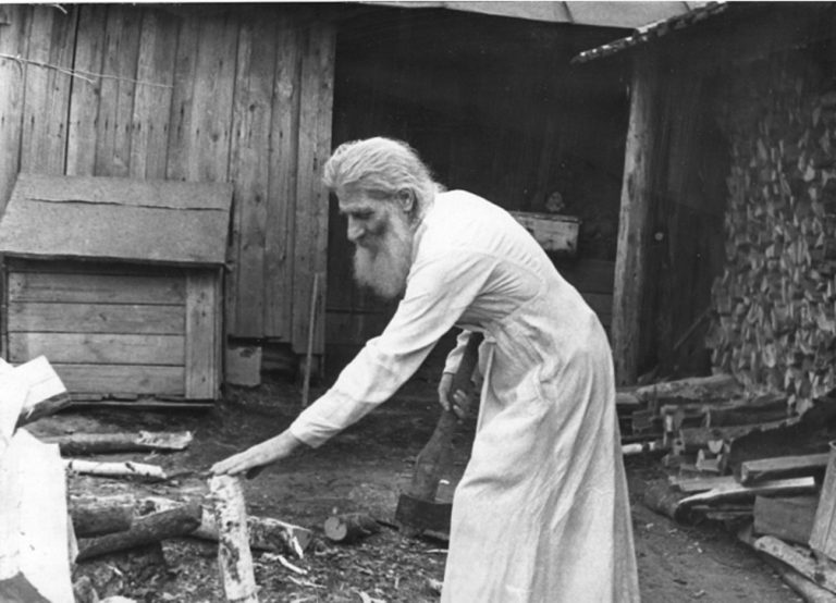 Владыка Товия во дворе своего дома рубит дрова, 50-е гг.